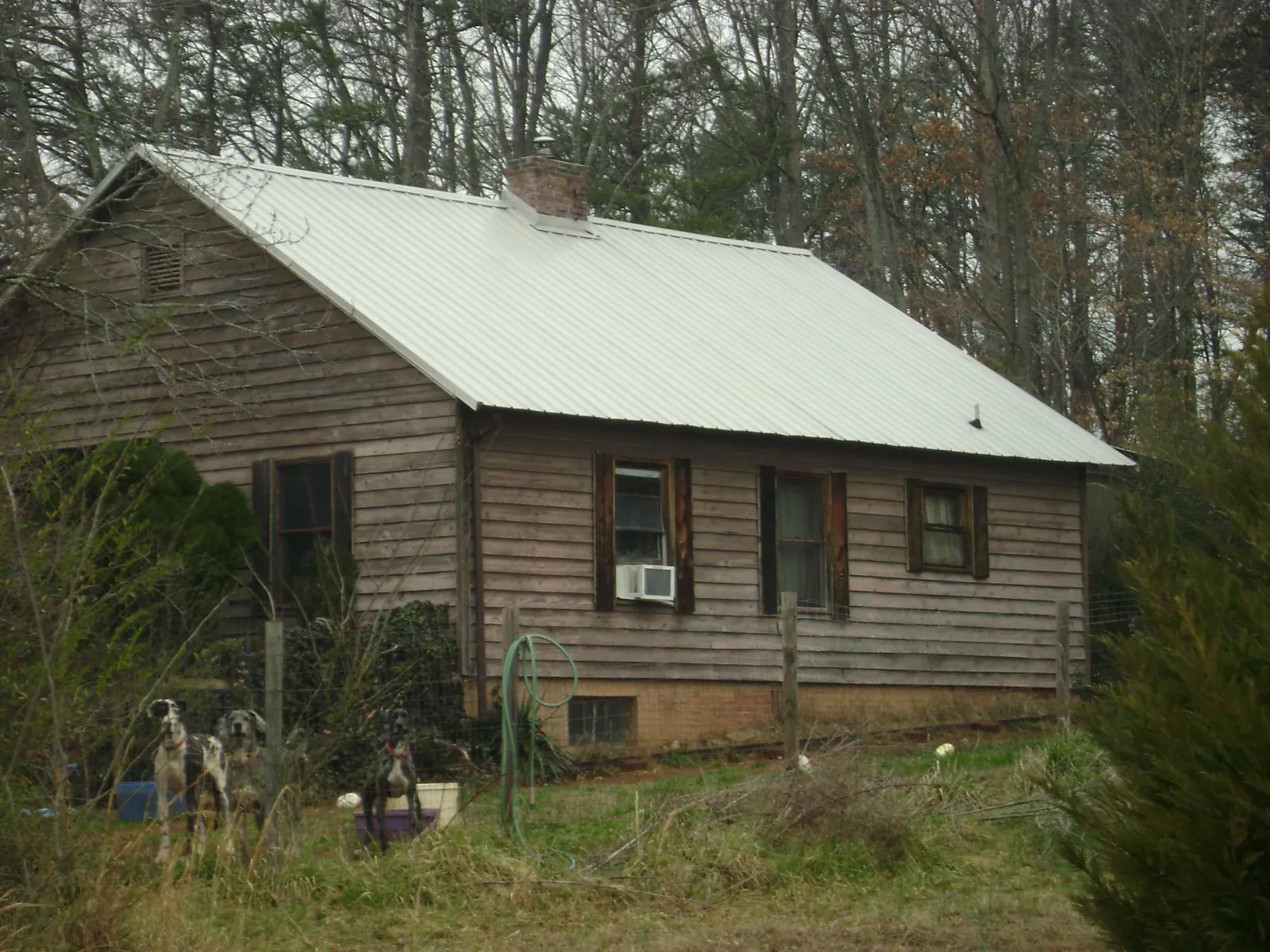 White metal roof on an old wood sided farmhouse, from a Metal Roof Installation job in Blanchard